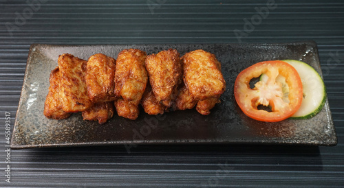 deep fried pork fish meat roll wrapped with bean curd skin ngohiang on dark grey wood background dim sum menu photo