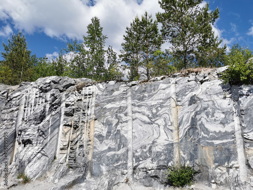 Italian quarry with smooth sections of marble in the Ruskeala Mountain Park on a sunny summer day.