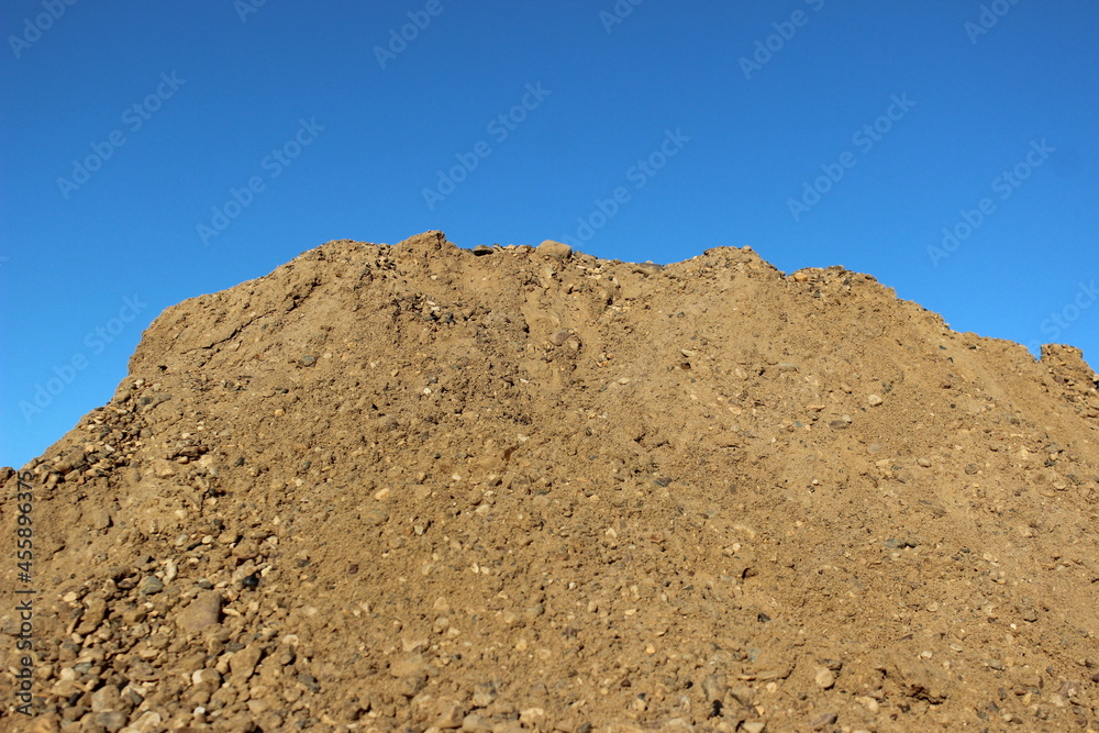 Background of sand with pebbles in the sunlight