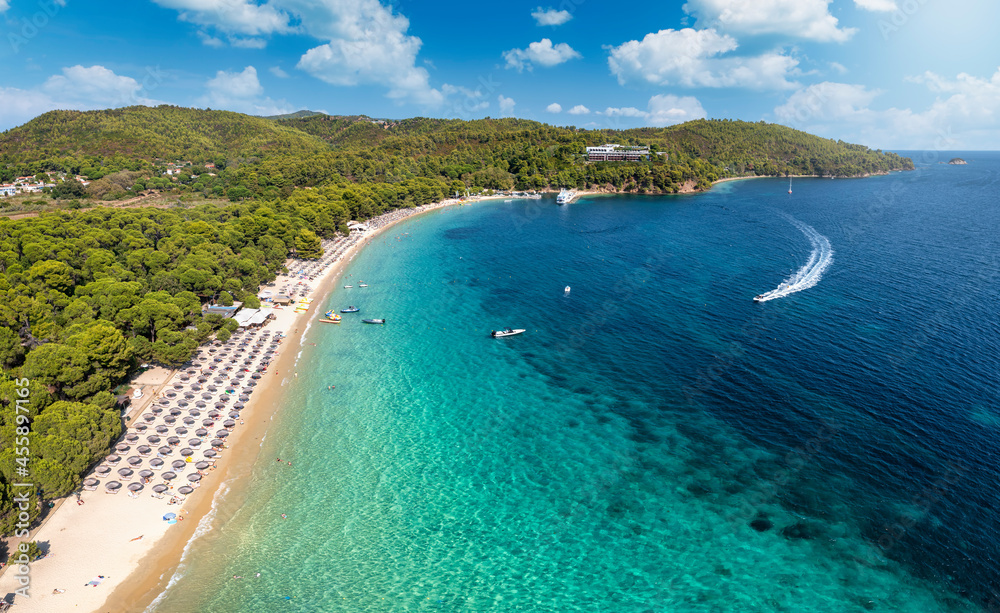 Beautiful Koukounaries beach on the island of Skiathos, Sporades, Greece, with emerald shining sea and lush vegetation on the surrounding hills