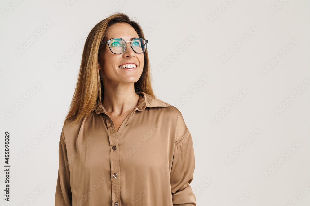 European ginger woman in eyeglasses laughing and looking aside