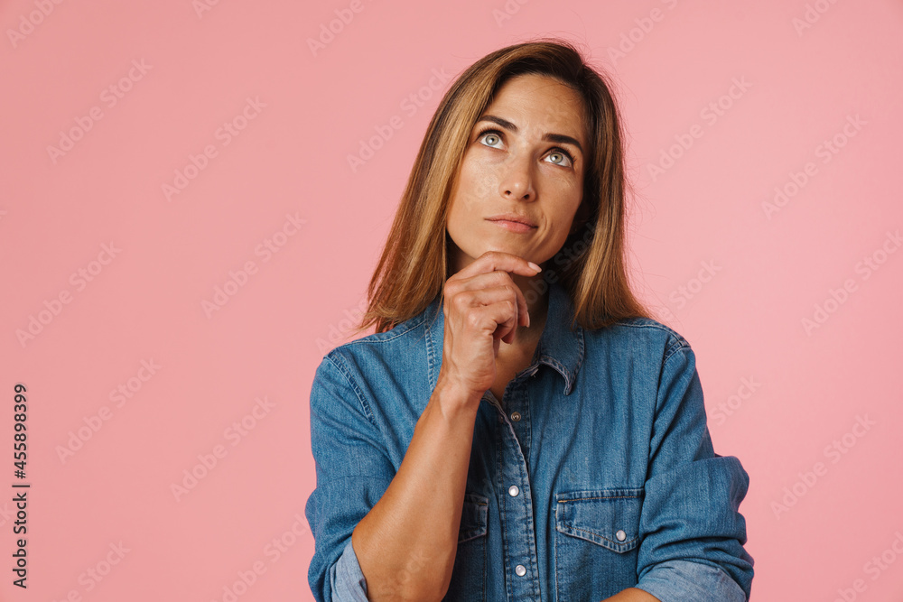 European ginger woman in denim shirt frowning while looking upward European ginger woman in denim shirt frowning while looking upward