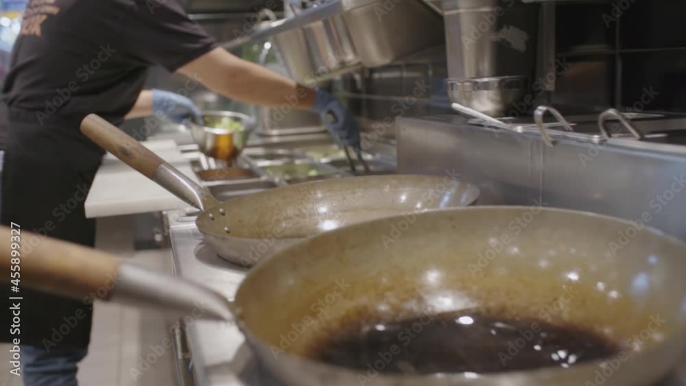 Fast food kitchen counter with worker making salad Fast food kitchen counter with worker making salad
