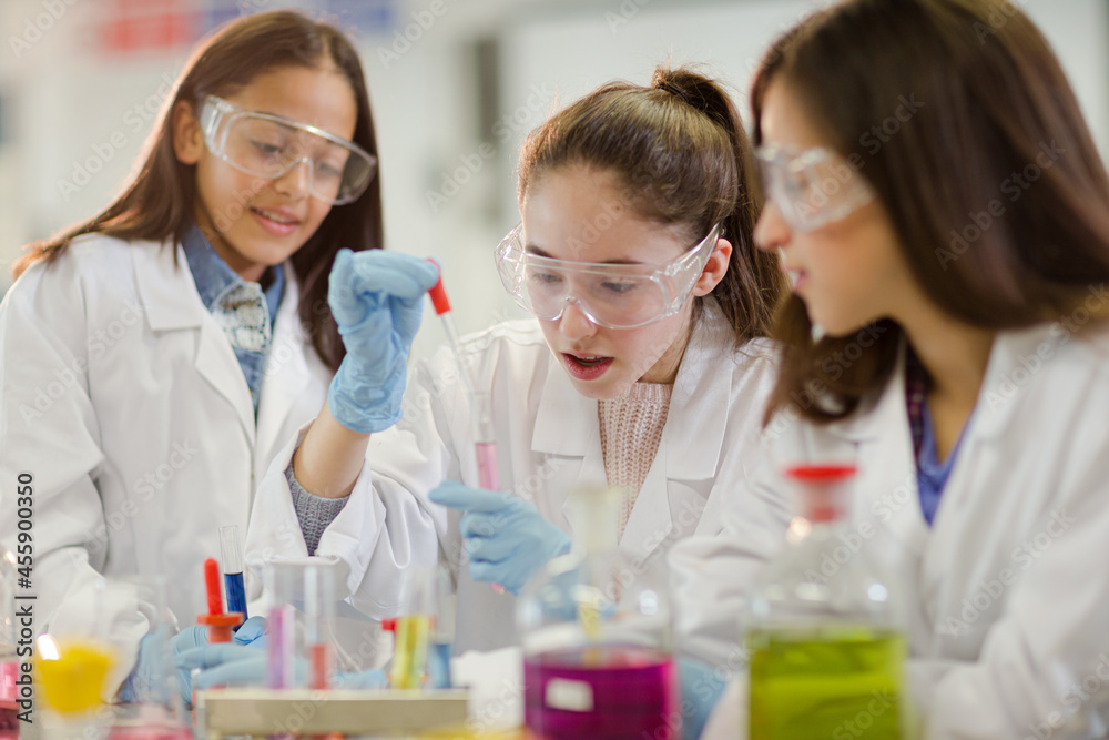 Girl students conducting scientific experiment in laboratory classroom