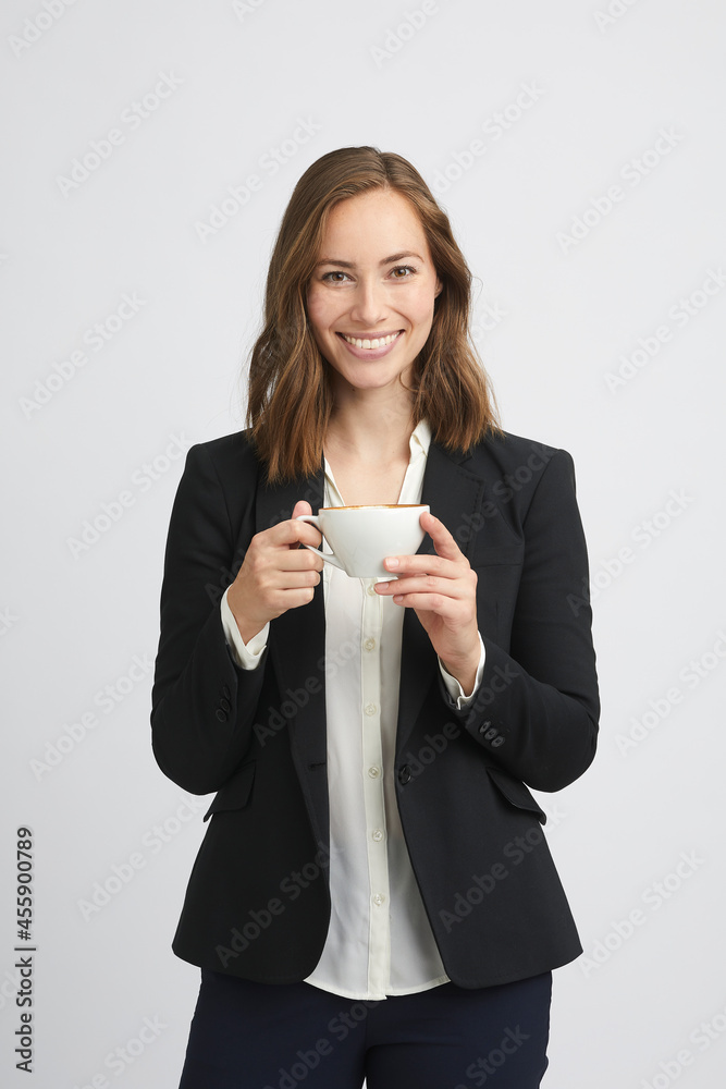 Portrait of a beautiful and gorgeous young business woman holding a cup of coffee upfront and giving a big smile to the camera on white background Portrait of a beautiful and gorgeous young business woman holding a cup of coffee upfront and giving a big smile to the camera on white background