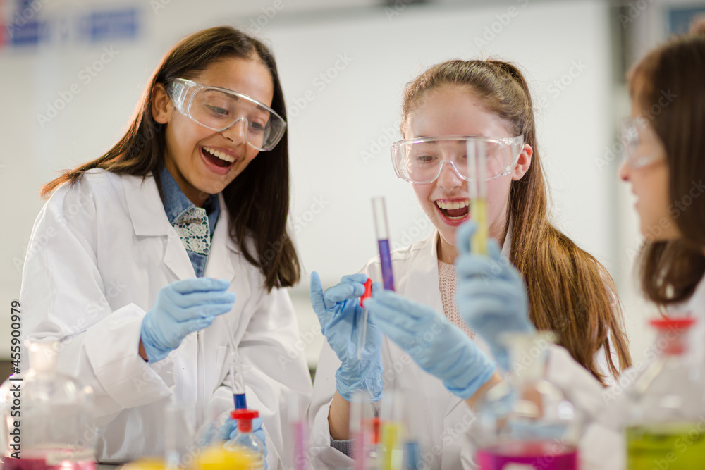 Girl students conducting scientific experiment in laboratory classroom Girl students conducting scientific experiment in laboratory classroom