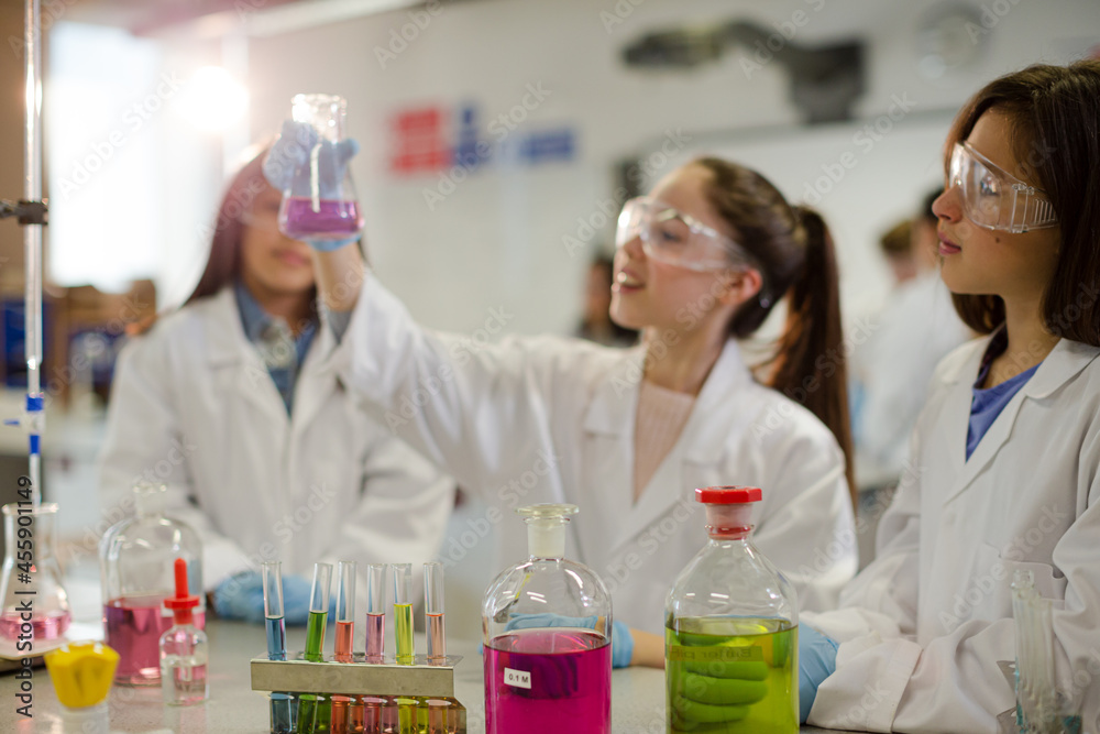 Girl students conducting scientific experiment in laboratory classroom Girl students conducting scientific experiment in laboratory classroom