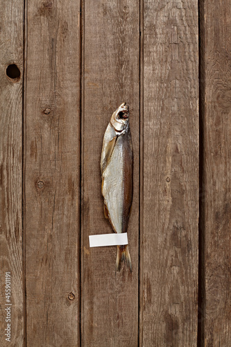 Air-dried sabrefish with label on tail on wooden background photo