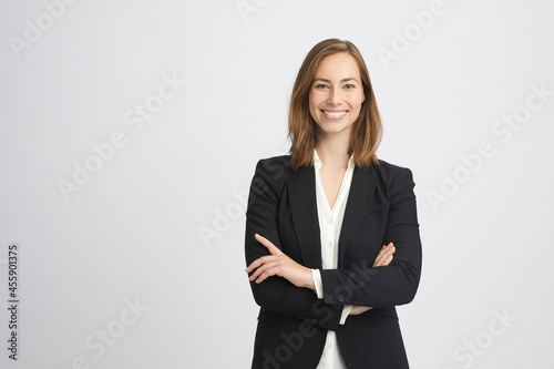 Beautiful and professional young business woman smiling and crossing her arms looking like a boss on white background photo