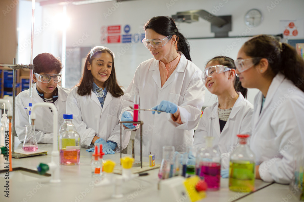 © KOTO - Female teacher and students conducting scientific experiment, watching liquid in test tube in laboratory classroom
