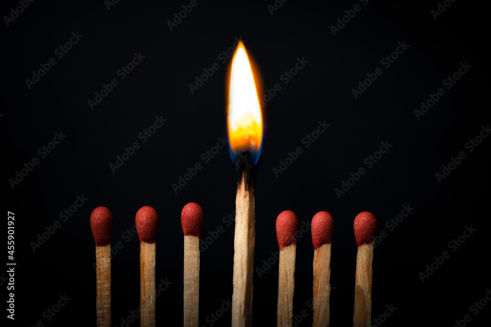 Burning match on dark black background. Difference and uniqueness concept. Burning match on dark black background. Difference and uniqueness concept.