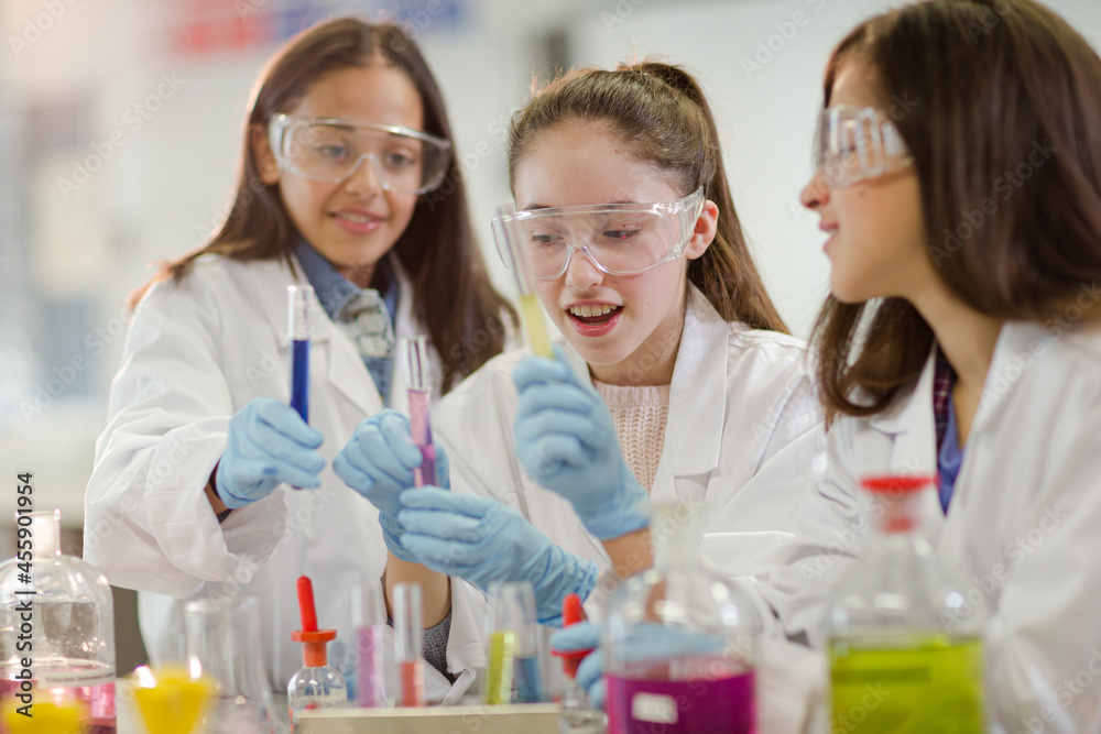 Girl students conducting scientific experiment in laboratory classroom Girl students conducting scientific experiment in laboratory classroom