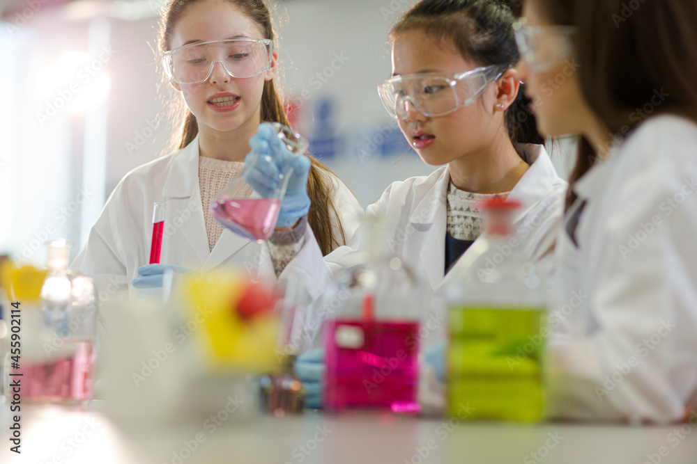 Girl students conducting scientific experiment in laboratory classroom Girl students conducting scientific experiment in laboratory classroom