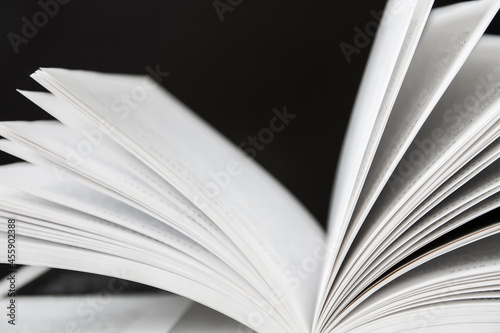 Closeup of opened book's pages on the dark background. Closeup, selective focus