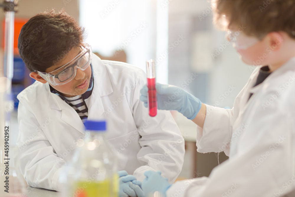 Boy students examining liquid in test tube, conducting scientific experiment in laboratory classroom Boy students examining liquid in test tube, conducting scientific experiment in laboratory classroom