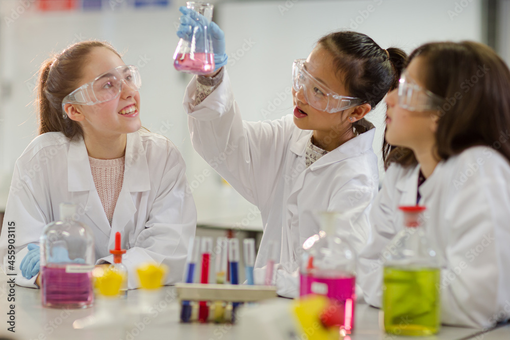 Girl students conducting scientific experiment in laboratory classroom Girl students conducting scientific experiment in laboratory classroom