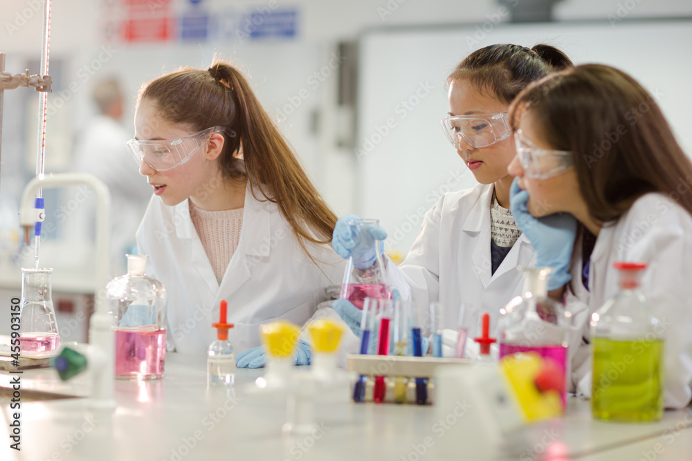 Girl students conducting scientific experiment in laboratory classroom Girl students conducting scientific experiment in laboratory classroom