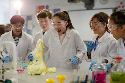 Surprised students conducting exploding foam scientific experiment in classroom laboratory photo