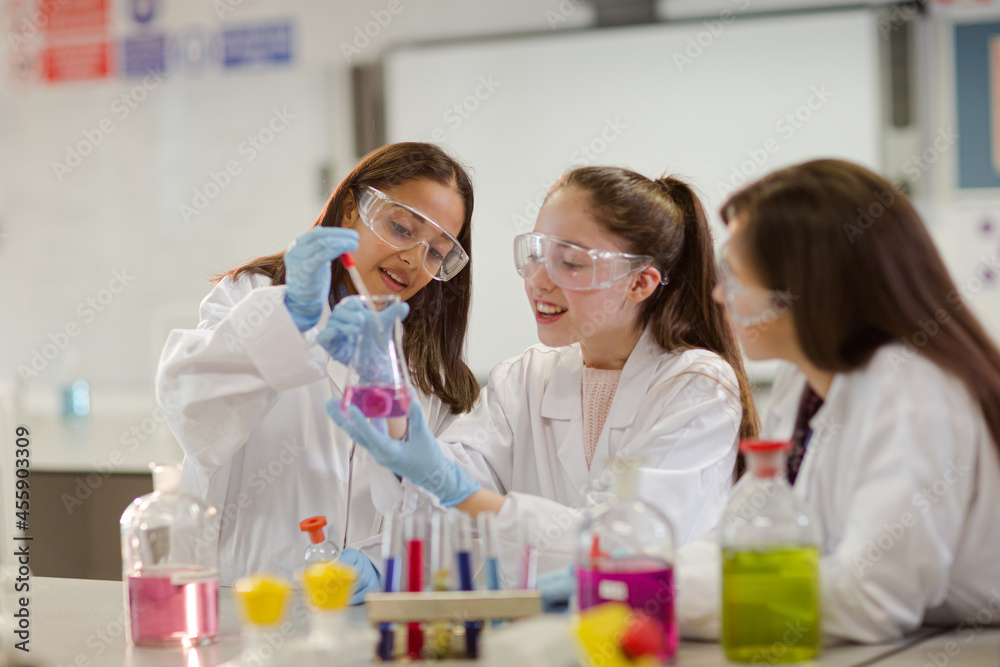 Girl students conducting scientific experiment in laboratory classroom Girl students conducting scientific experiment in laboratory classroom