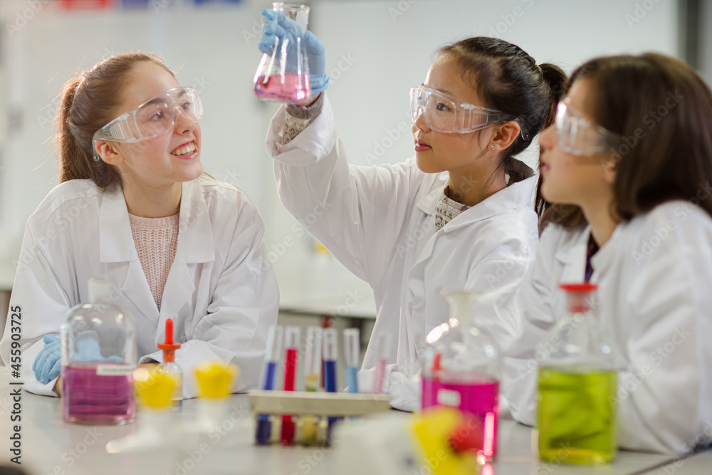 Girl students conducting scientific experiment in laboratory classroom Girl students conducting scientific experiment in laboratory classroom