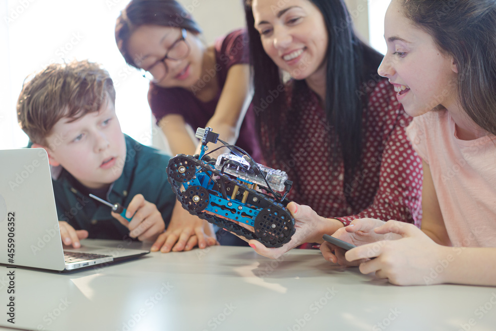 Fototapeta premium Female teacher and students playing with robot in classroom