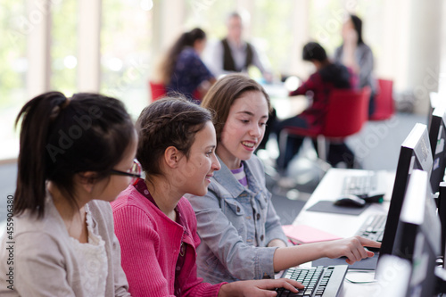 Girl students using computer in library