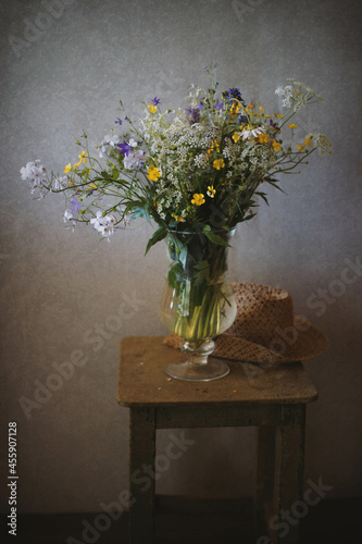 A bouquet of flowers on a wooden chair, gray background.