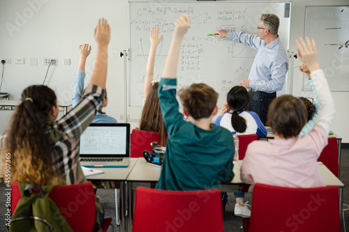 Obraz na plátně Male teacher leading lesson at whiteboard in classroom