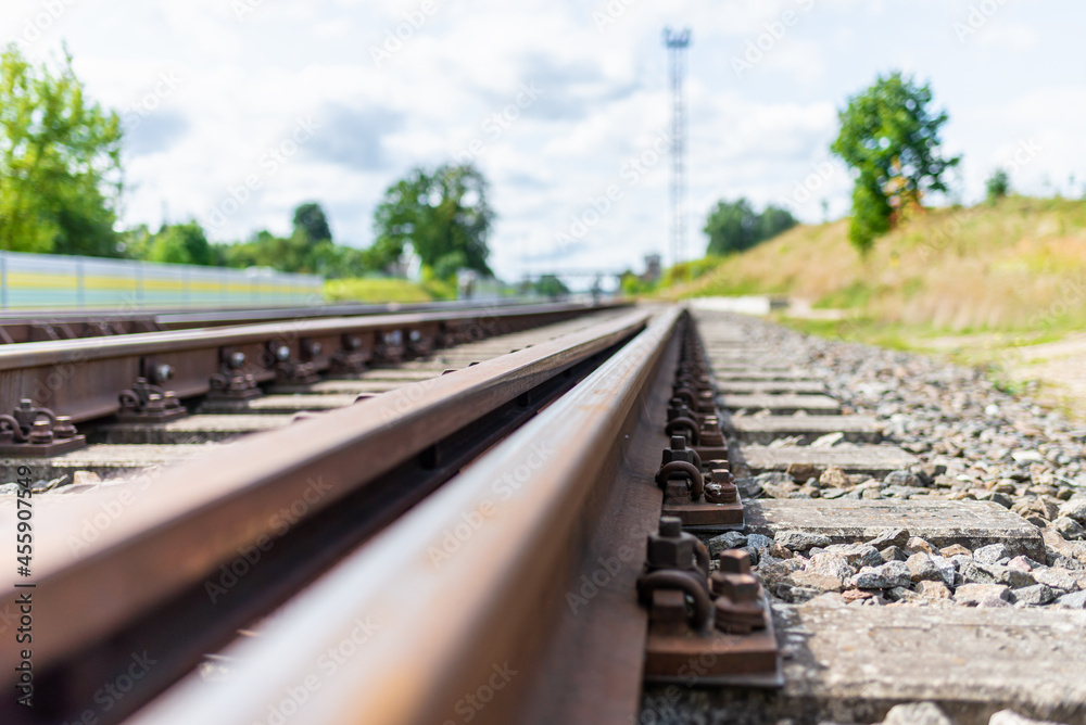 Railway track details closeup photo with selective focus.Close-up view of railway bolts.Summer day details of railway Railway track details closeup photo with selective focus.Close-up view of railway bolts.Summer day details of railway
