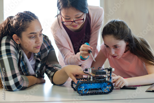 Students playing with robot in classroom