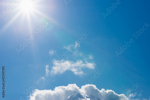 Shining sun at clear blue sky,clouds.Solar lens flare. copy space.Natural lens flare.