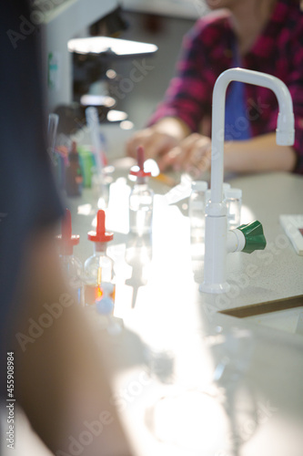 Liquid in bottles, test tubes and beakers in science laboratory classroom