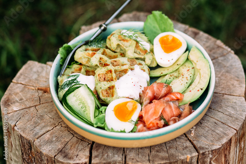 Belgian waffles with salmon, avocado and egg in a plate