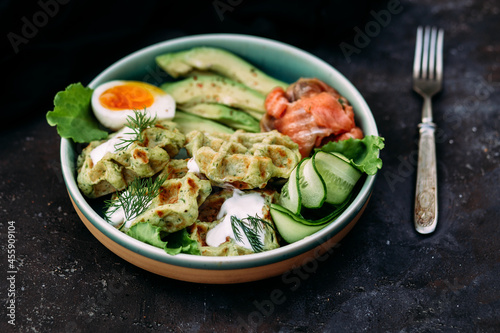 Belgian waffles with salmon, avocado and egg in a plate
