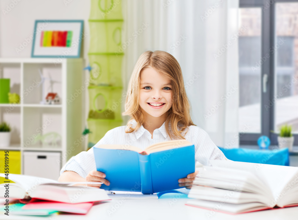 education and school concept - happy smiling student girl reading book over home background education and school concept - happy smiling student girl reading book over home background