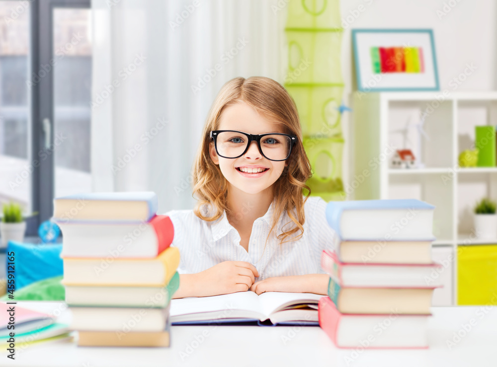 education and school concept - happy smiling student girl in glasses with books learning over home room background education and school concept - happy smiling student girl in glasses with books learning over home room background