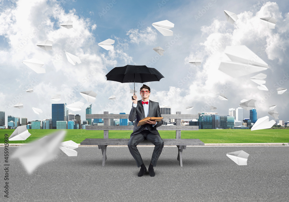 young businessman with an umbrella and a book young businessman with an umbrella and a book