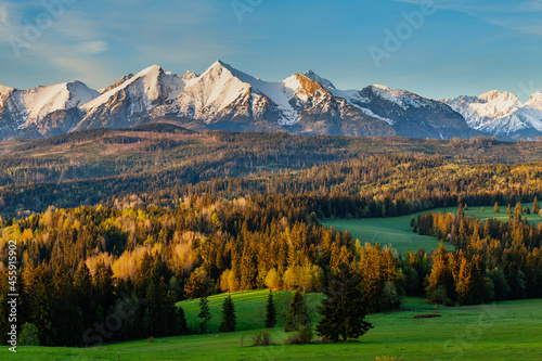 Beautiful sunrise over the Tatra Mountains. Snow-capped peaks lit by golden rays of the sun. View of the Belianske Tatras.