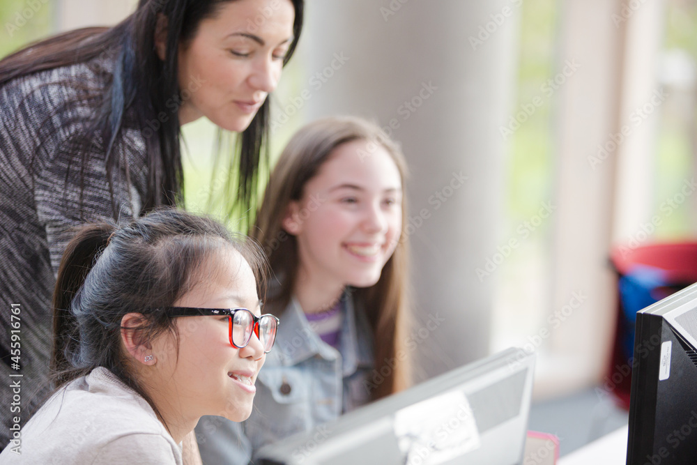 Female teacher and girl students using computer Female teacher and girl students using computer