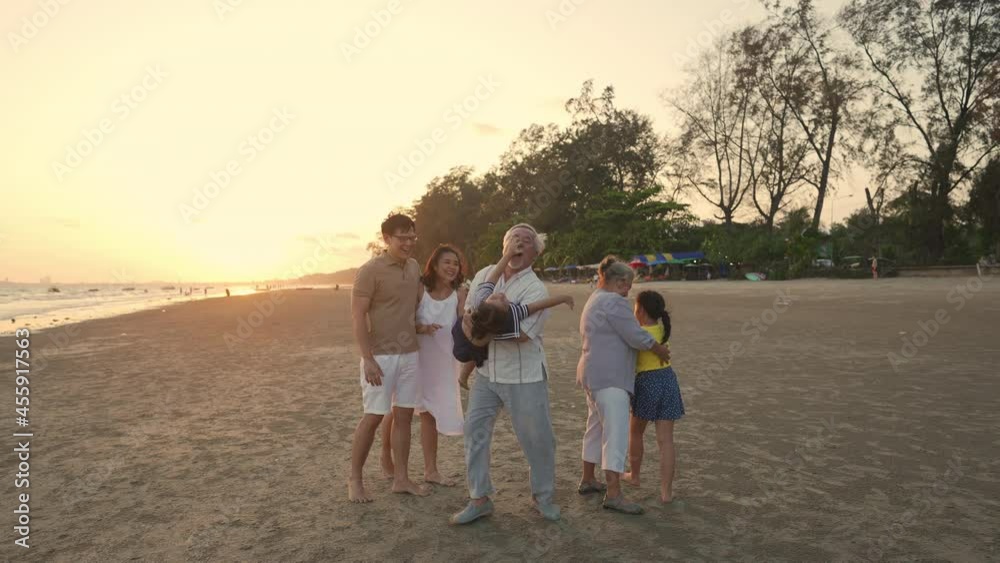 Happy big Asian family on beach holiday vacation. Multi-generation family holding hands and walking together on tropical beach at summer sunset. Family enjoy and having fun outdoor activity lifestyle. Happy big Asian family on beach holiday vacation. Multi-generation family holding hands and walking together on tropical beach at summer sunset. Family enjoy and having fun outdoor activity lifestyle.