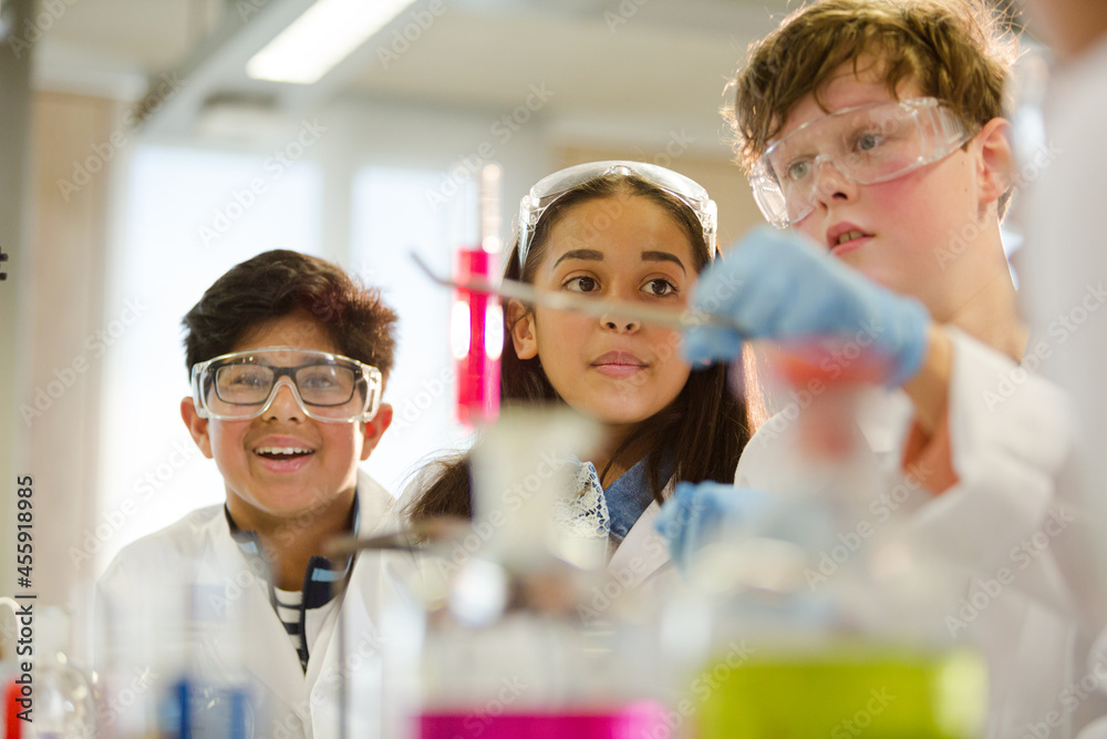Students examining liquid in test tube, conducting scientific experiment in laboratory classroom Students examining liquid in test tube, conducting scientific experiment in laboratory classroom
