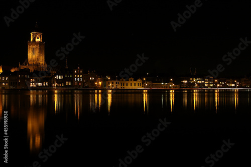 A view on  the houses and the Great Church in the City of Deventer  the Netherlands  at night with reflection in the water