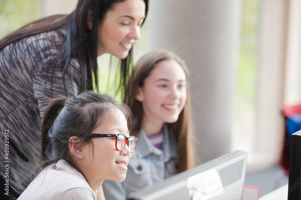 Female teacher and girl students using computer Female teacher and girl students using computer