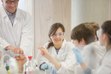Male teacher and student conducting scientific experiment in laboratory classroom