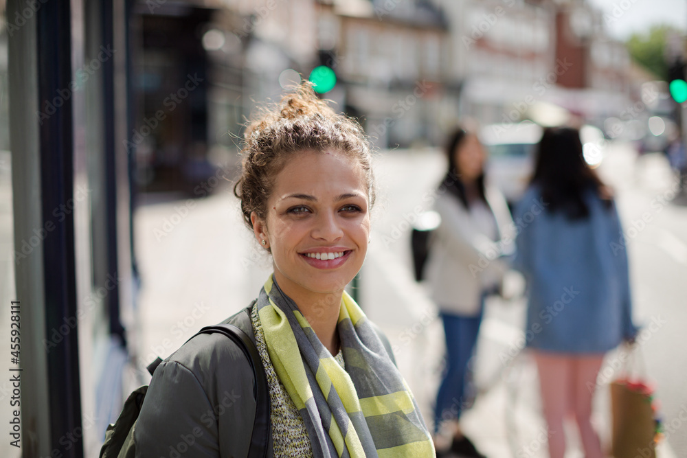 Portrait smiling young woman on sunny urban street Portrait smiling young woman on sunny urban street