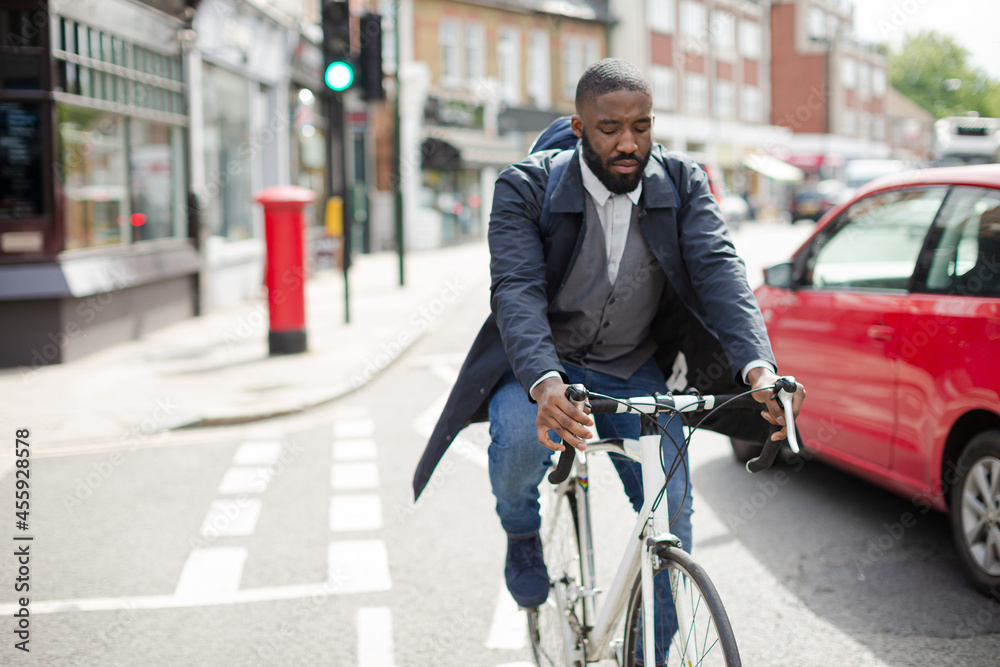Young businessman commuting, riding bicycle on urban street Young businessman commuting, riding bicycle on urban street