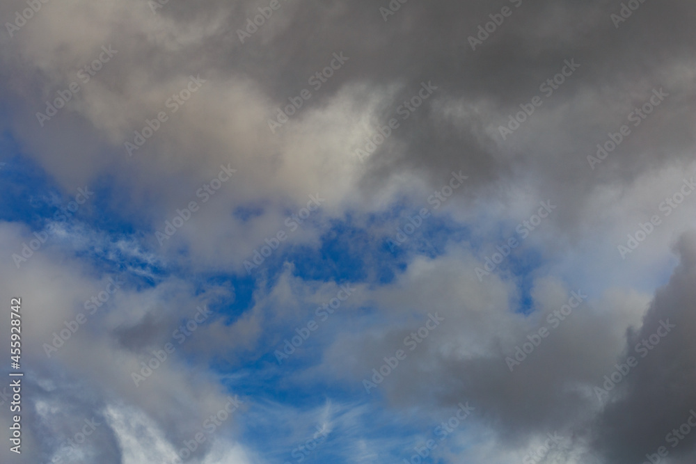 Fototapeta premium Dark storm clouds on a bright blue sky. Sky patterns background 2021.