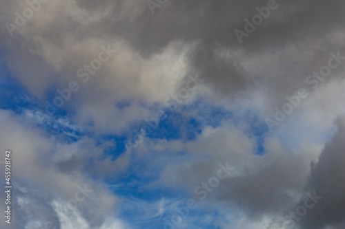 Dark storm clouds on a bright blue sky. Sky patterns background 2021.