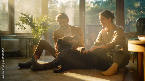 At Home: Happy Couple Play with Their Dog, Gorgeous Brown Labrador Retriever. Boyfriend and Girlfriend Tease, Pet and Scratch Super Happy Doggy, Have Fun in the Stylish Living Room