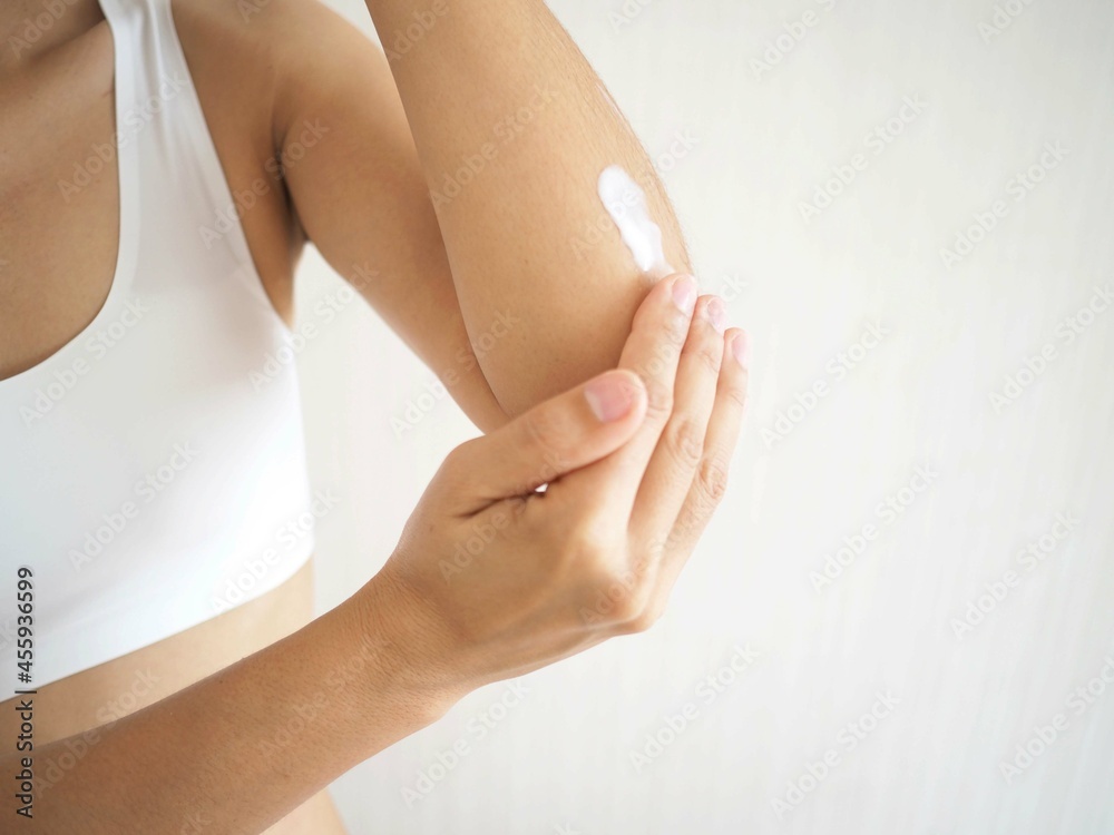 Woman applying elbow cream, lotion. Hygienic and beauty skin care body concept. closeup photo, blurred.
